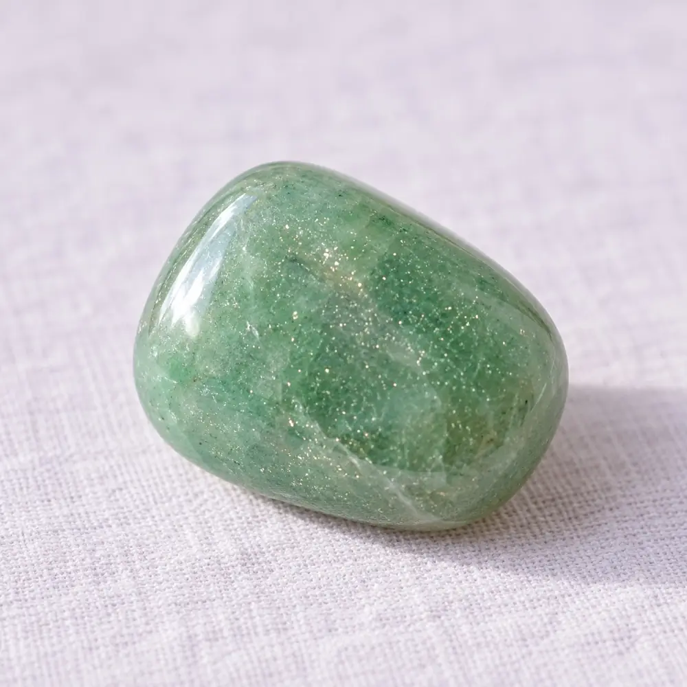 Aventurine verte posée sur un lin lavande