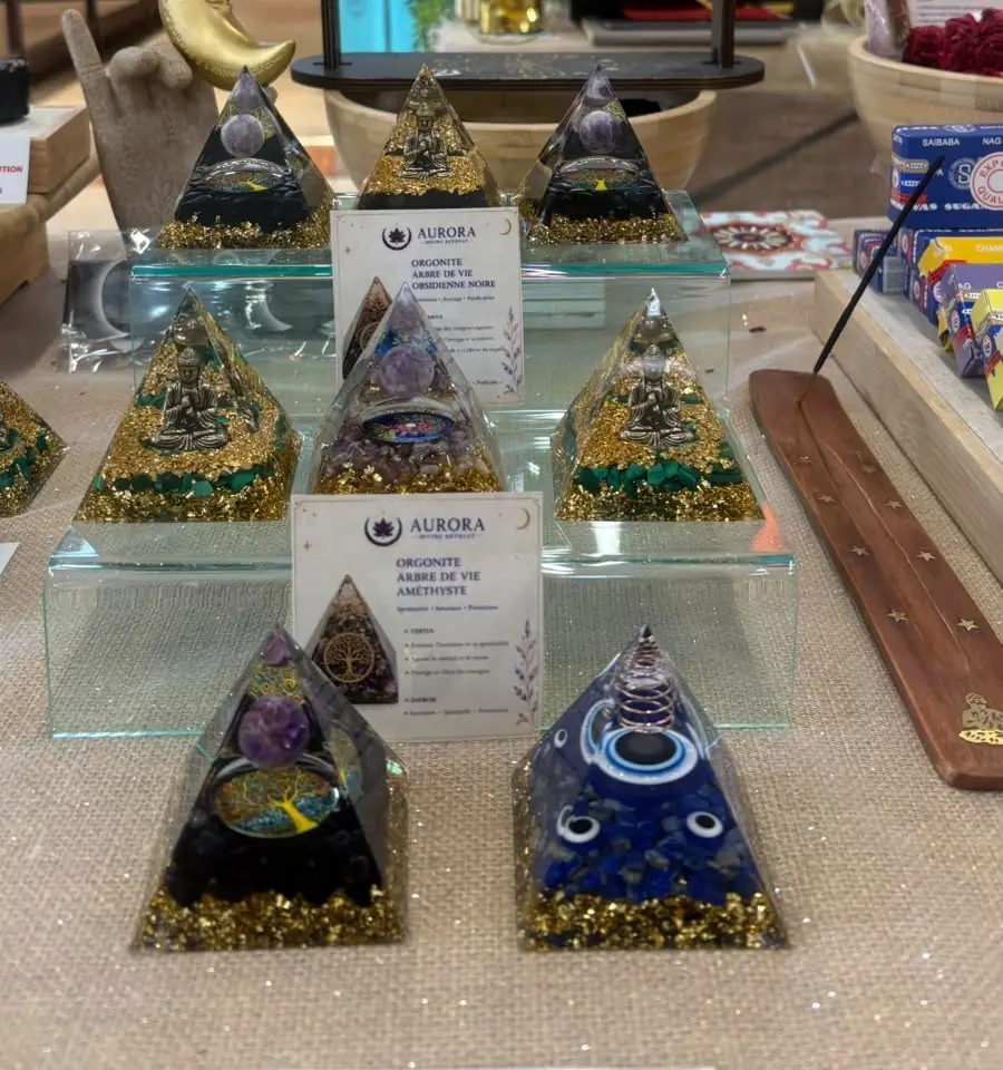 Orgonites en pyramide présentées sur une étagère en verre