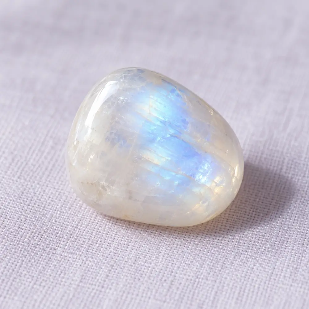 Pierre de lune posée sur un lin lavande